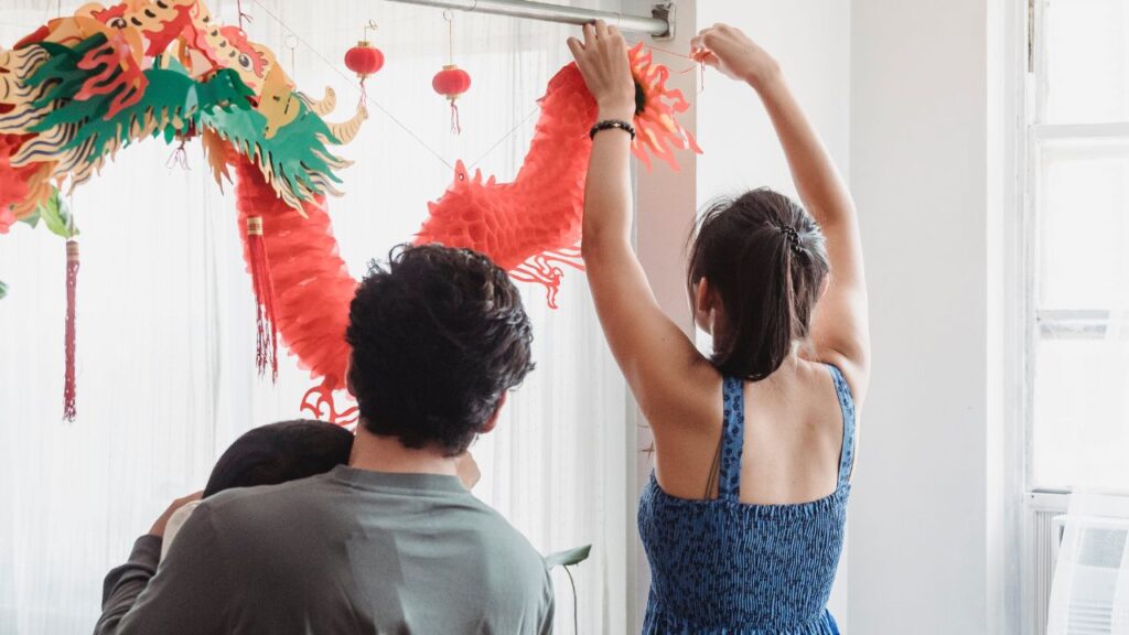 a woman decorating home with red decorative items with her partner