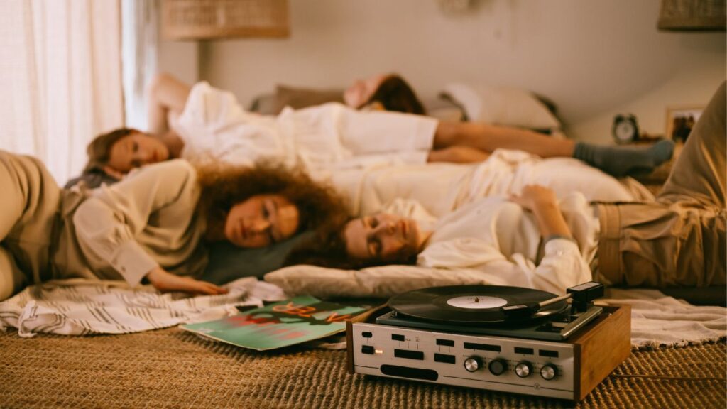 3 girls sleeping in a room with a disc player on the ground