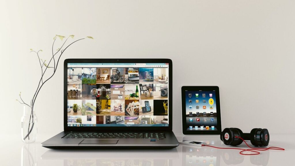 laptop and tablet along with a headphone on a table with white background