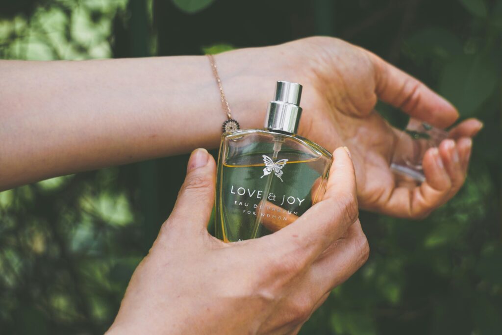 an image of a girls hand with perfume in it