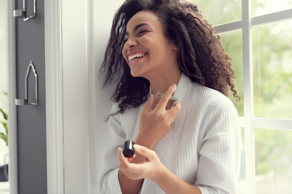An image of a woman spraying perfume 