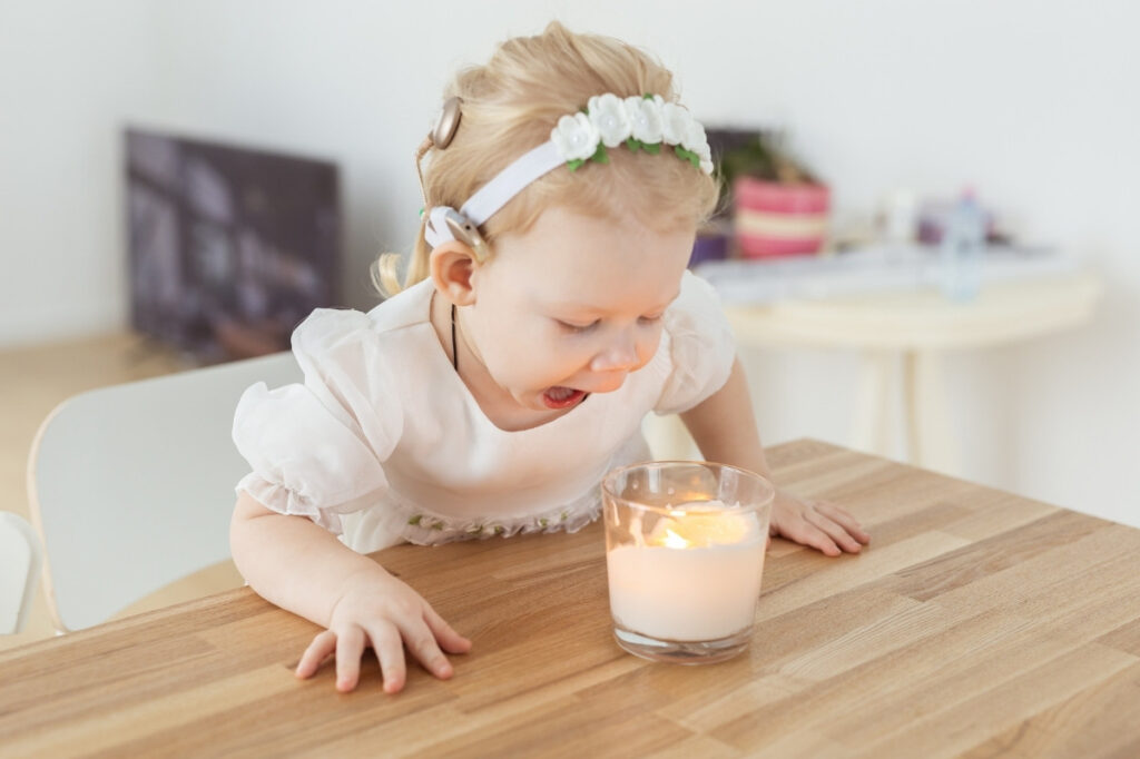 AN image of a baby blowing a perfumed candle