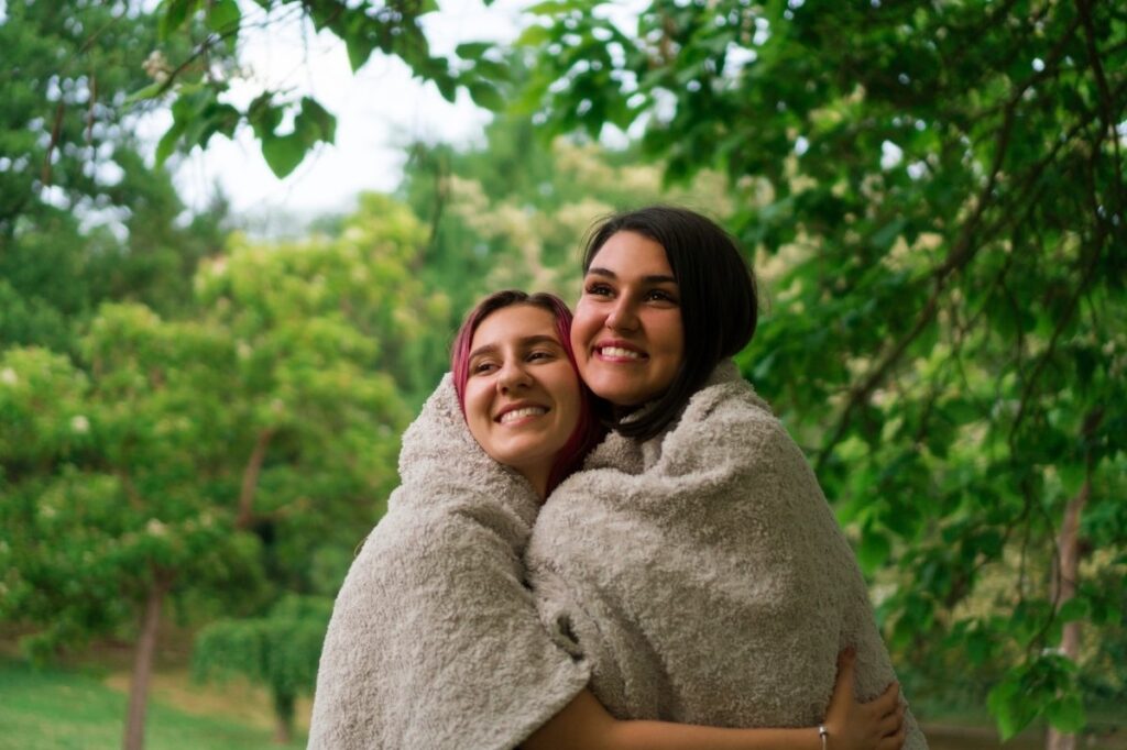 An image of 2 girls with a blanket