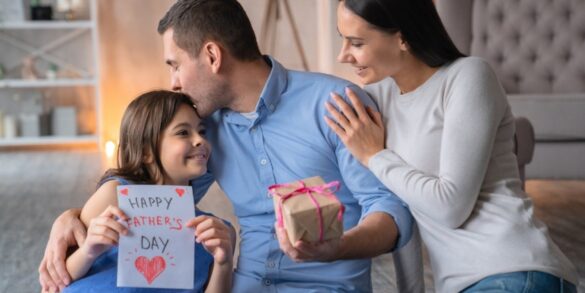 صورة لعائلة مع ابنتها وهي تحمل ملصق "عيد أب سعيد" في يدها