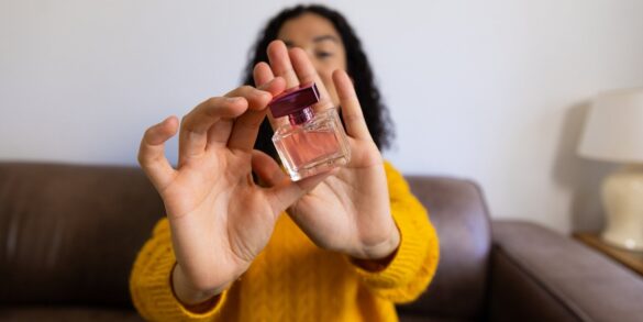 صورة لامرأة تعرض عطرًا أمام الكاميرا