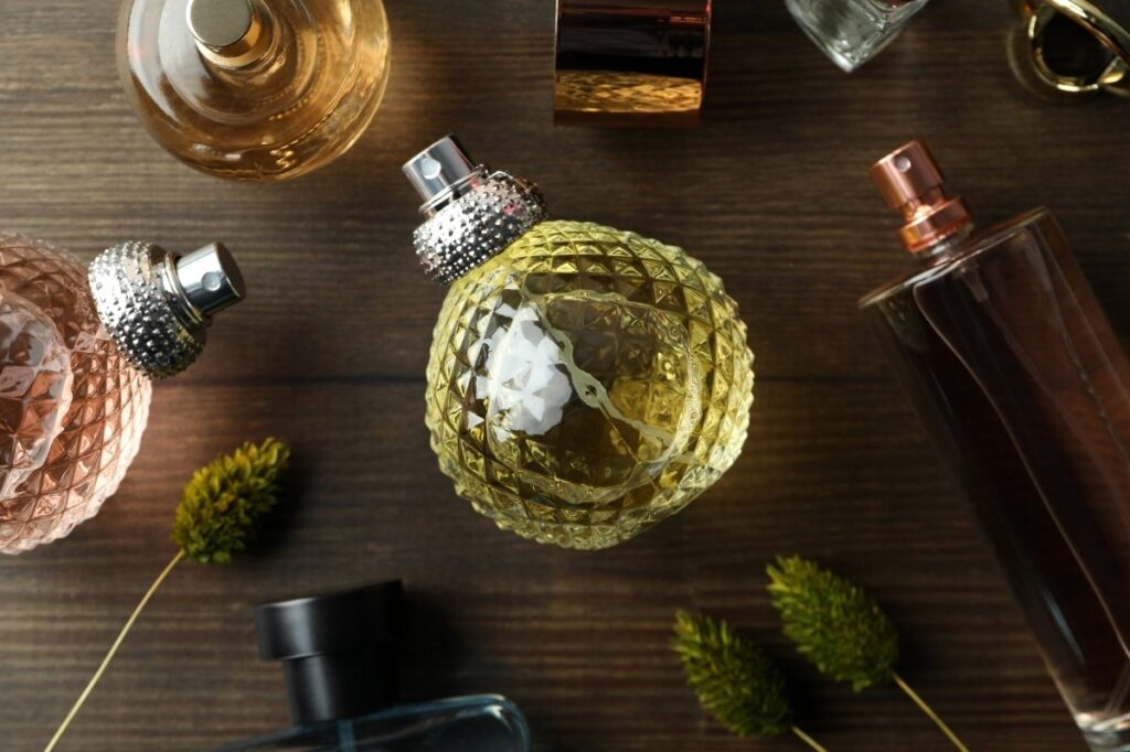 An image of several perfumes on a wooden top.