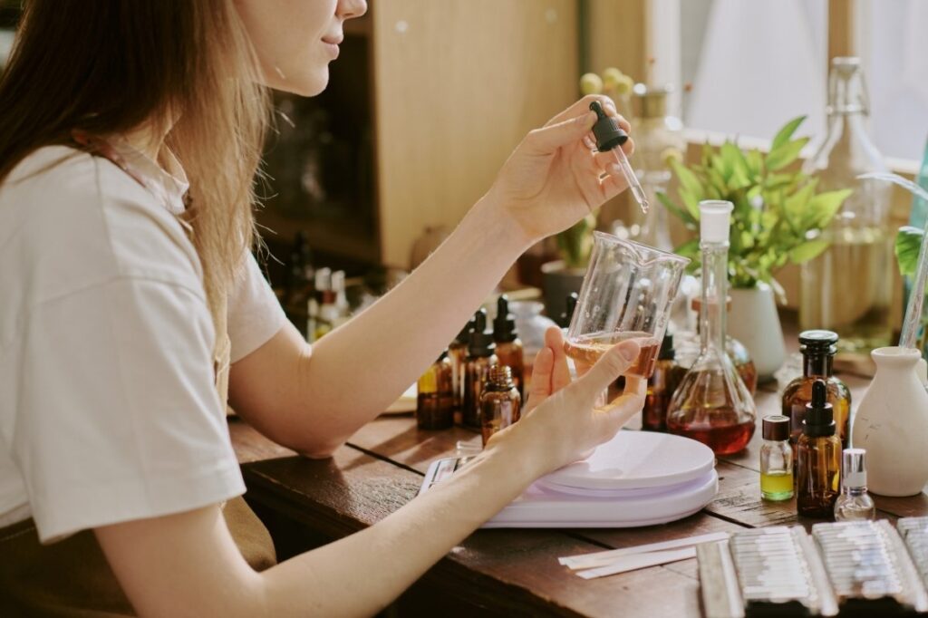 An image of a woman mixing different perfume oils