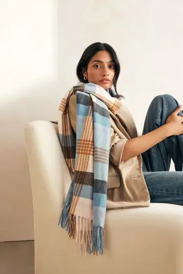 An image of a girl wearing a scarf and sitting on a couch.