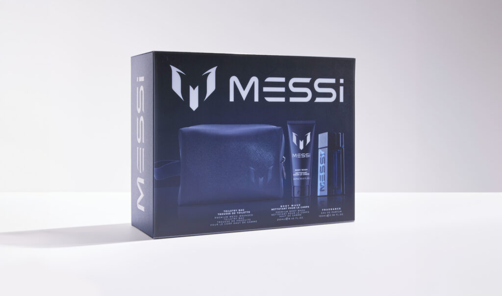 5 Football Stars Who Won the Fragrance Game 20 In this image the Messi giftset is placed on a white background. It has Messi's logo and branding. It has the images of PU Leather Travel Bag, Messi Bodywash and Messi EDP. The color of the packaging is blue.