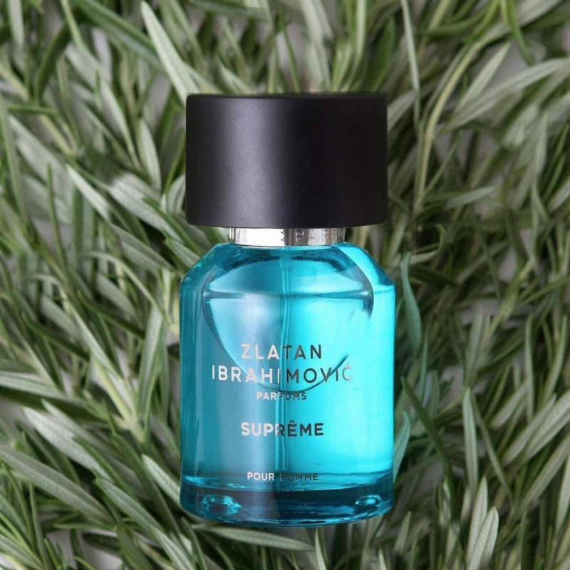 5 Football Stars Who Won the Fragrance Game 32 In this image Zlatan Ibrahimović Suprême Pour Homme Eau de Toilette bottle displayed against a blue background, surrounded by visual representations of its fragrance notes: zesty lemon, spicy ginger, vibrant pink pepper, and warm woody accords, capturing the fresh and dynamic essence of the scent.
