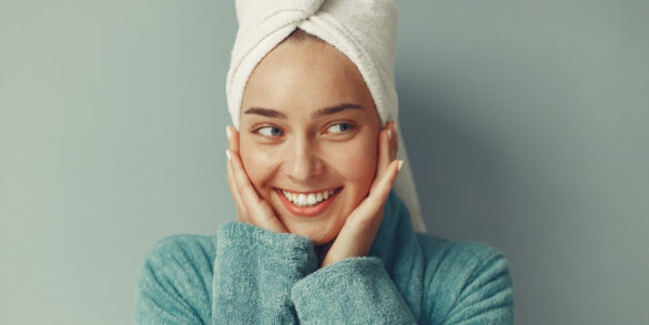 Isang larawan ng isang babaeng naka-bathrobe kasama ang kanyang skin care routine