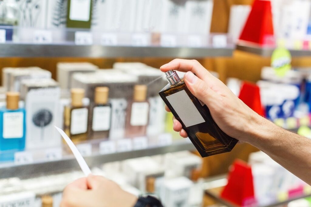 An image of a person testing a perfume while spraying it on tester paper