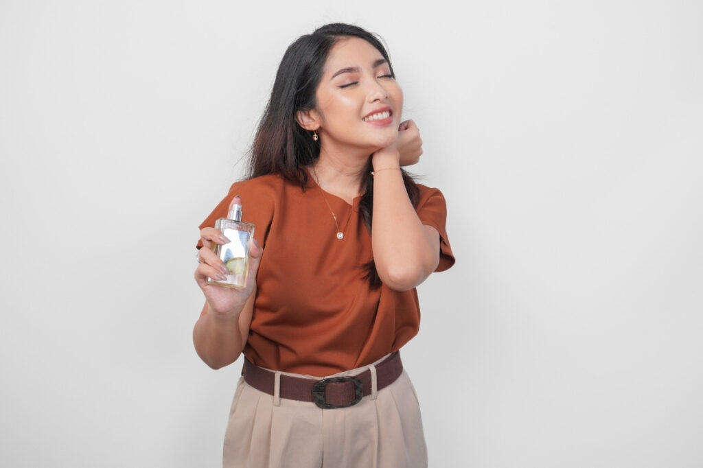 An image of a woman trying out her perfume