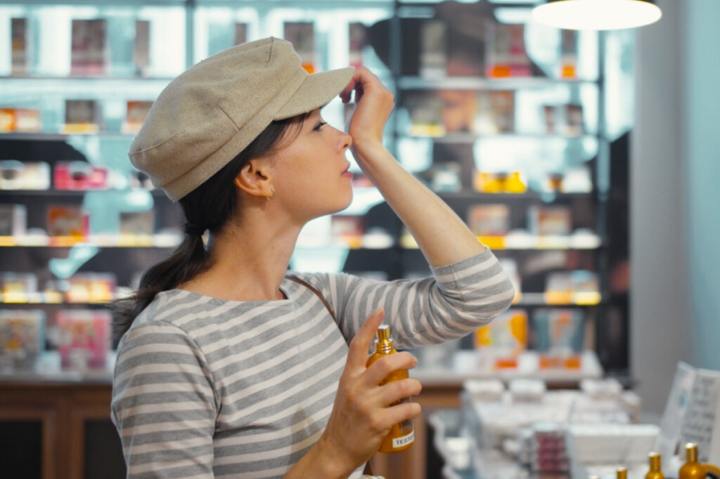 An image of a woman smelling perfume in a perfume store