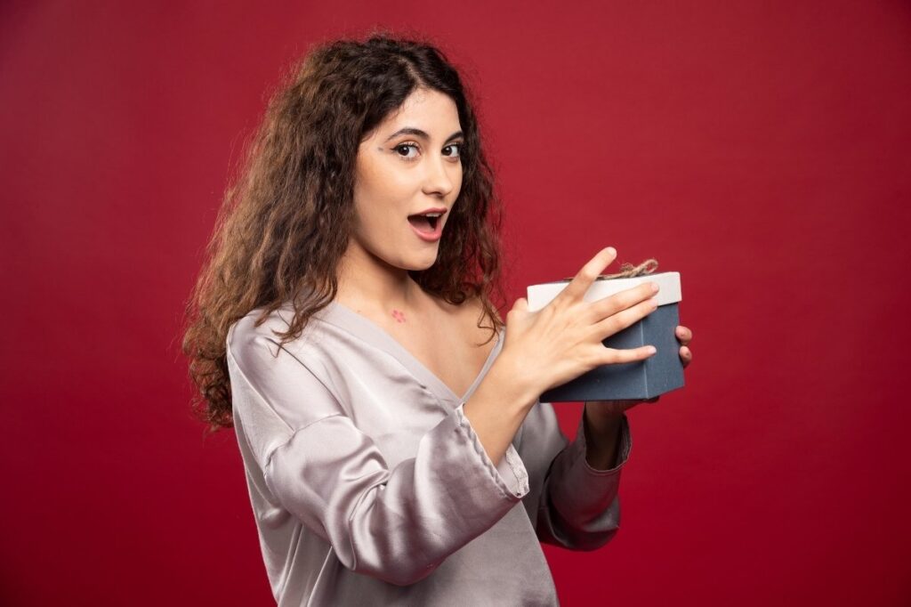 An image of a surprised woman opening a gift box