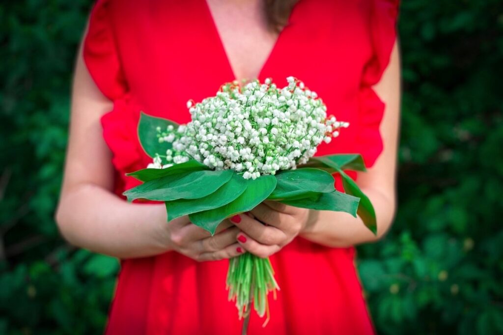The Best Smelling Flowers Found In Perfumes 22 An image of a woman with a bouquet of lily of valley