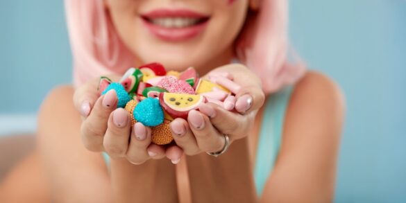 Une image d'une femme avec différents types de bonbons et de sucreries dans sa main