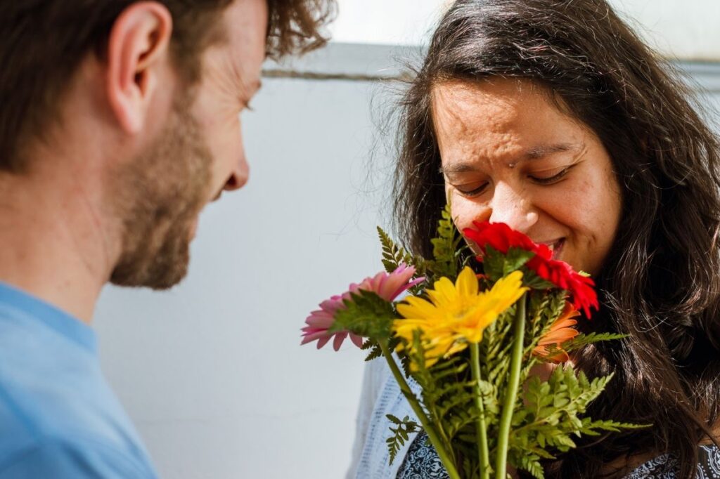 An image of a woman smelling a flower 