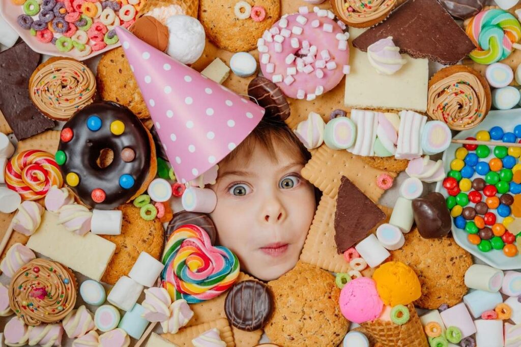 The Gourmand Switch From Sweet to Savory: The Next Fragrance Trend 18 An image of a little girl lying under plenty of sweet foods.