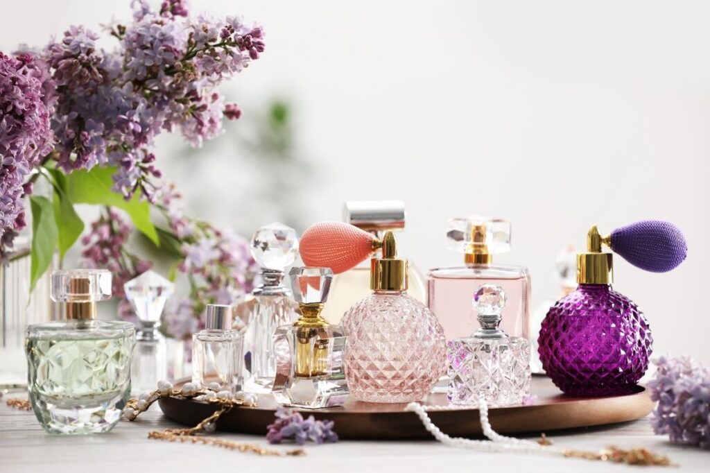 An image of bottles of perfume accessories and flowers