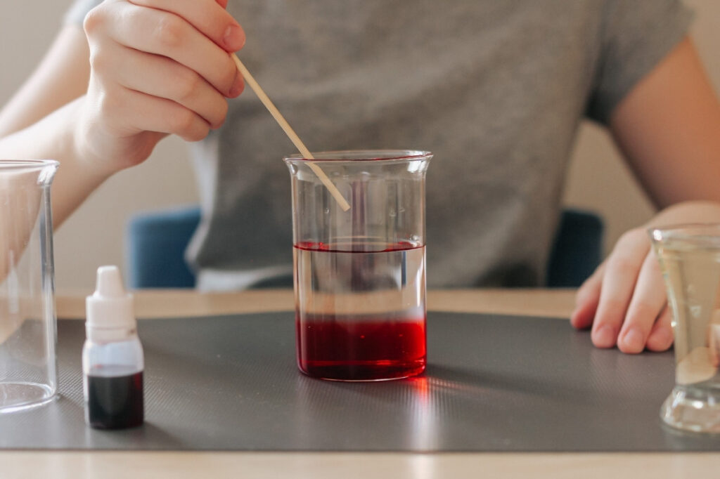 An image of a girl filling glass with color